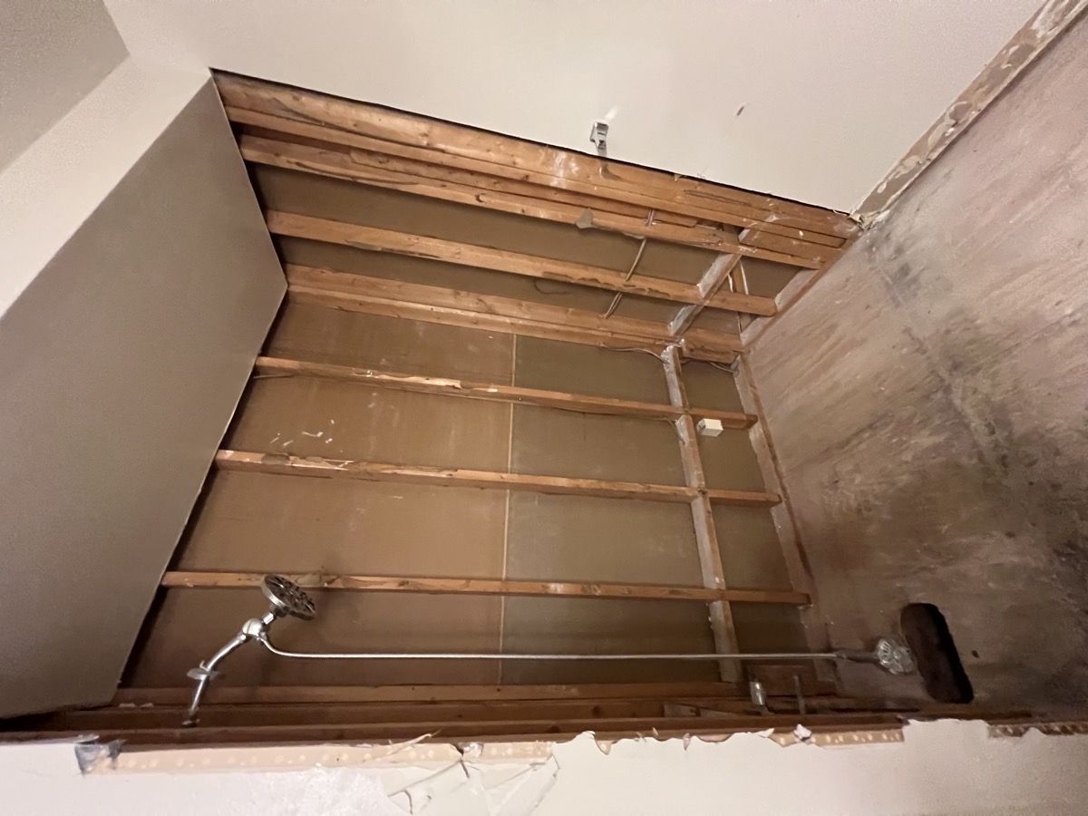 Bathroom demolition with drywall removed exposing wall studs